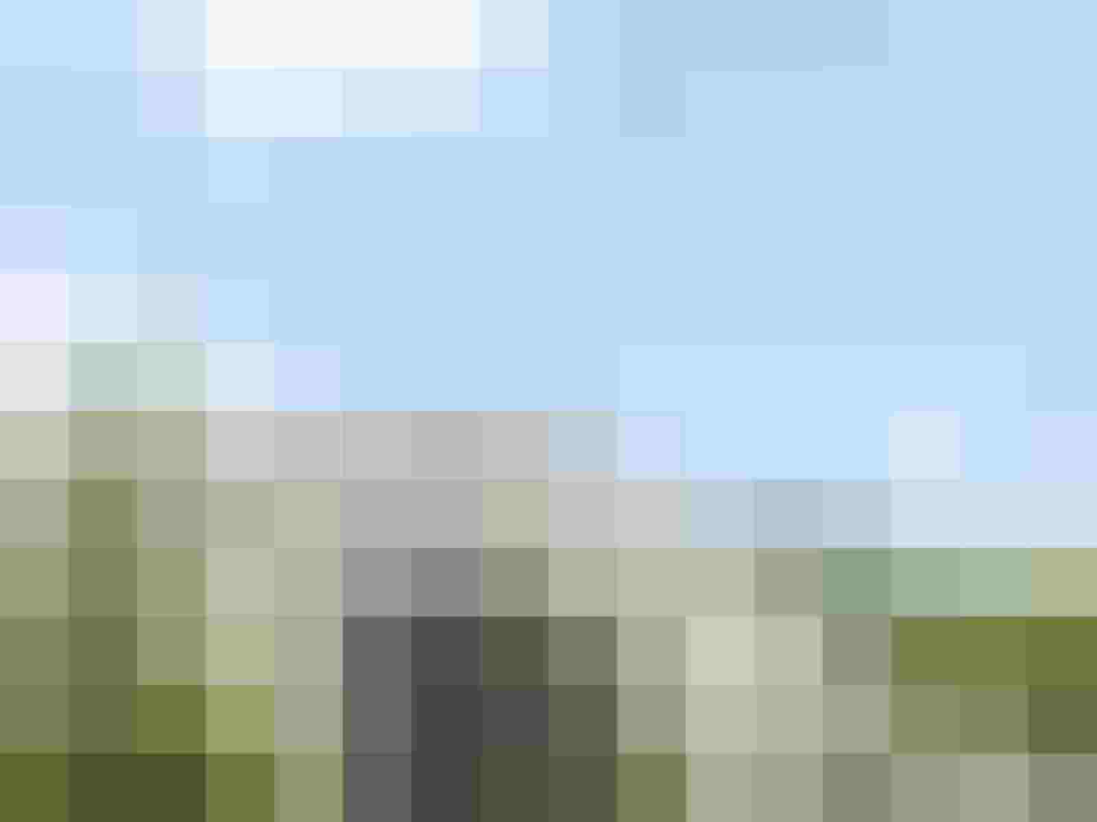 Unscharfes Gebäude mit blauem Himmel und Bäumen